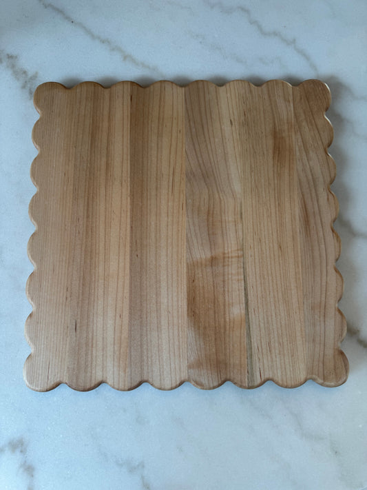 Haylee scalloped-edge cutting board made from solid maple hardwood, shown on a marble surface